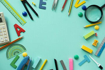 Different stationery and calendar on green table background, flat lay. Space for text, back to school concept