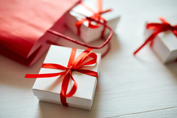 Gift boxes out from red paper bag on white background. Romantic Valentines day present, red and...