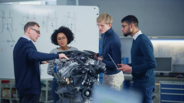 Team Meeting of Engineers Working on Innovative Electric Motor. Group of Specialists Gathered Around Table, Solving Problems. Research, Development, Digitalisation of Green Electric Energy Concept