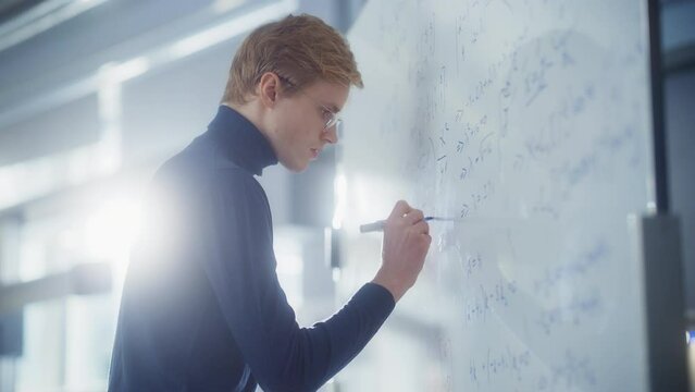 Male Scientist Drawing Formulas and Elements on the Whiteboard, Signs and Symbols of Chemistry. Education, Learning, Mathematics Concept. Portrait Shot