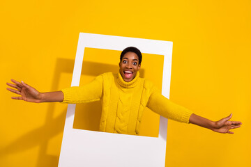 Portrait of attractive cheerful funky girl coming out frame comfort zone isolated over bright...