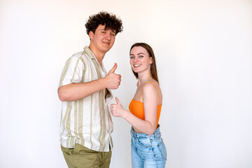 Loving couple posing o making thumbs up sign n a white background