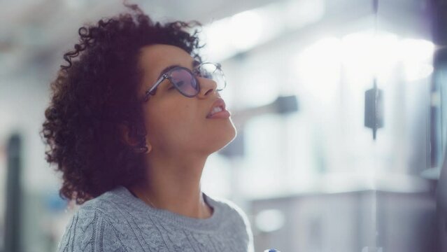 Positive Young Female Specialist Solving Math Problems on a Whiteboard. Science Breakthrough and Discovering New Concept. Portrait View