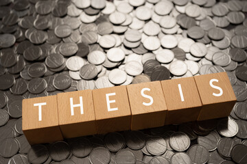 論文・主題・命題のイメージ｜「THESIS」と書かれた積み木とコイン