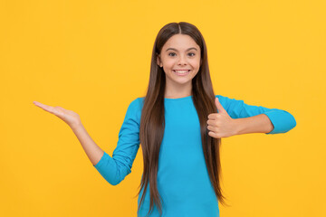 happy pretty look of young girl. face portrait of child on yellow background.