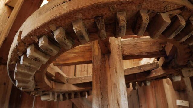 Wooden interior with a gear wheel of an old traditional wooden windmill. Camera panorama.