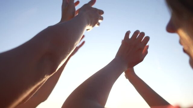 group of cheerful people together party pulling hands to the sun on the beach. teamwork. silhouette people party dancing recreation holiday fun. people music. pull their hands up. religion concept