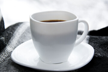 White cup of coffee on soft plaid. Good morning concept