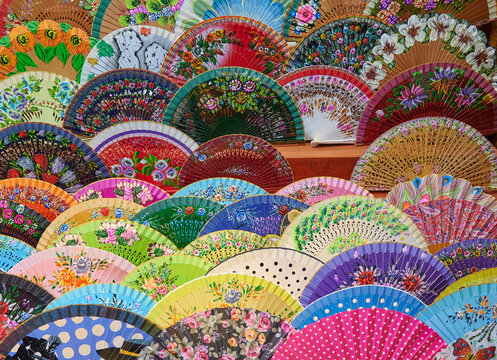 Spanish hand fans made by local artisan, painted by hand are on sale in a bazaar like souvenirs. Hand craft items.