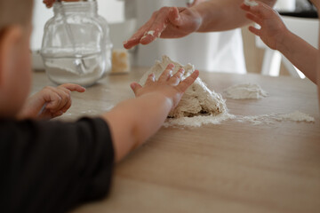 children's hands touching yeast dough