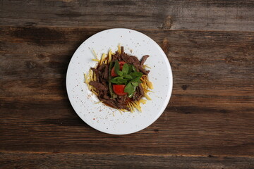 appetizers next to red meat on french fries on white plate