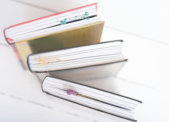  hardcovered books with dry flower bookmarks on a table. Bookshop background. reading and education, study and learning concept.