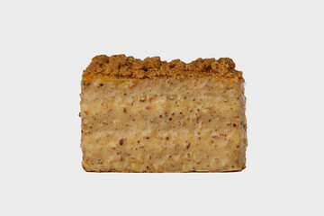 Front view image of medovik cake with honey decorated with nuts isolated at white background.