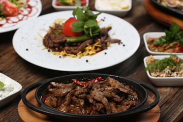 appetizers next to red meat on french fries on white plate