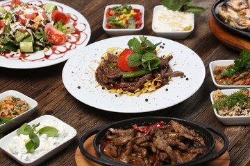 appetizers next to red meat on french fries on white plate