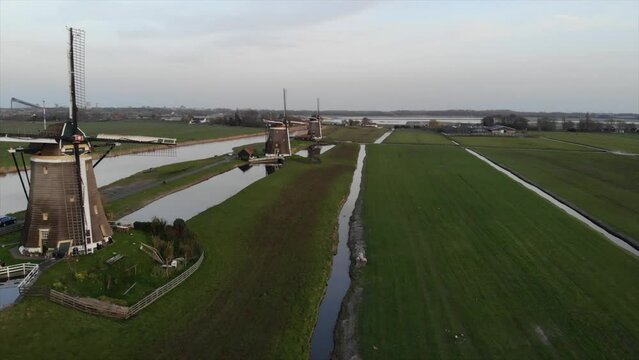 Three Dutch mills in 'polder' landscape Leidschendam, the Netherlands filmed with drone
