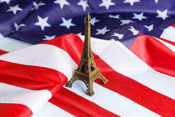 Miniature of the Eiffel Tower on the background of the American flag. Close-up. A place to copy. Travel