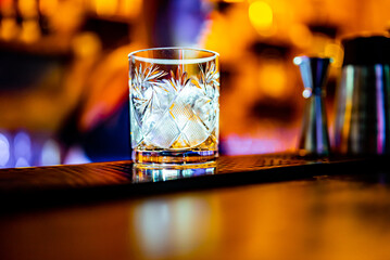 ice cube in an empty glass on a bar counter in bar or pub