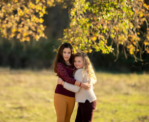 Fototapeta premium Portrait of two charming kind cheerful girls wearing casual hugging good mood