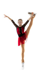 Portrait of little flexible girl, figure skater wearing stage attire posing isolated on white...