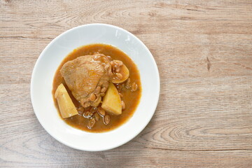 chicken thigh massaman curry with slice potato and peanut on plate