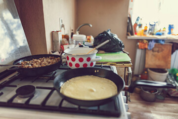 Cooking pancakes with meat filling in old kitchen in village