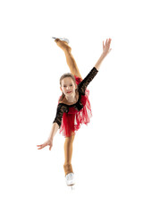 Portrait of little flexible girl, figure skater wearing stage attire posing isolated on white...