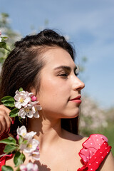 Fototapeta premium Young caucasian woman enjoying the flowering of an apple trees