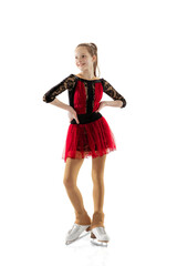 Portrait of little flexible girl, figure skater wearing stage attire posing isolated on white studio background. Concept of movement, sport, beauty.