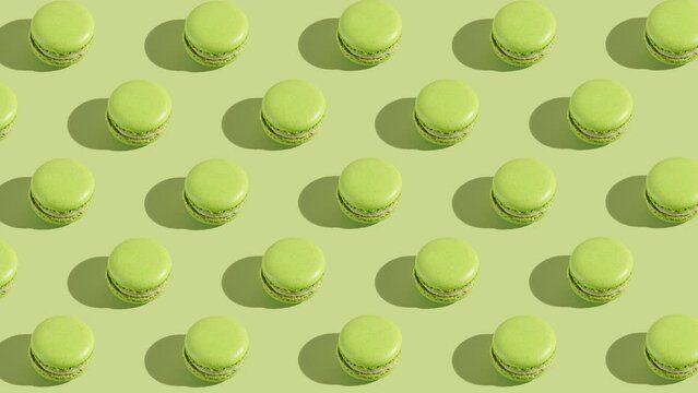 Green macaron pastries photographed on light green paper background appearing one by one creating a hard light pattern