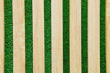 Wooden horizontal panels on the background of artificial green grass. Texture with copy space.