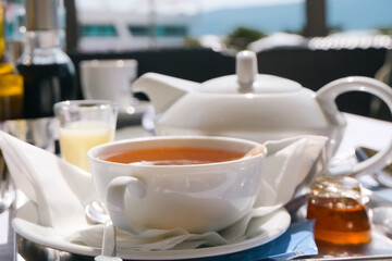 white morning cup of tea and teapot, breakfast time at cafe terrace, beautiful still life outdoor closeup
