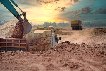 excavator at the construction site A crawler excavator is shoveling soil into a large dump truck or...