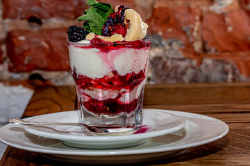 Cup of ice cream with fruits and nuts, sundae with cherries, raspberries and blueberries,
