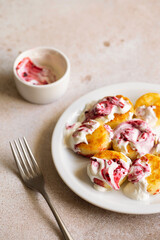Cottage cheese pancakes, syrniki, ricotta fritters on white ceramic plate with sour cream and jam. Healthy and delicious morning breakfast. Beige background. Food for kids