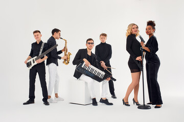 Portrait of diverse group of young people musical band playing with instruments - isolated on white background.