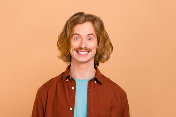 Portrait of attractive cheerful red-haired guy wearing shirt good mood isolated over beige pastel color background