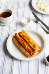 Fried Stuffed Pancakes Blintzes. Russian thin pancakes with cottage cheese, sour cream and jam. Healthy traditional breakfast.Tasty stuffed pancakes crepes with fillings. Kid's menu.
