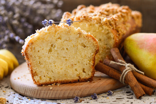 Cake in a cut. Garnished with pears and cinnamon sticks. Homemade baking. Wooden background.