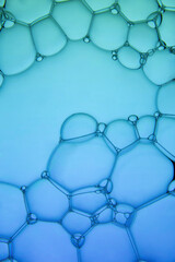 The surface of the bubbles. Extreme close-up of soap foam structure on green and blue. Cosmetic...