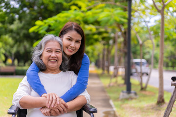 Asian careful caregiver or nurse taking care of the patient in a wheelchair.  Concept of happy retirement with care from a caregiver and Savings and senior health insurance, a Happy family