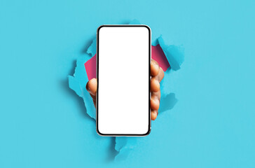 Black person showing white empty smartphone screen breaking through paper