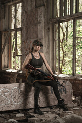 Ukrainian military girl sits with an AK-74 assault rifle inside a destroyed building