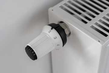 The white thermostat for adjusting the central heating radiator is set to the economical minimum temperature mode