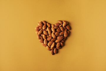 almond in heart shape over beige background