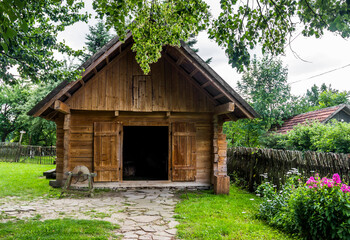 Fototapeta na wymiar vintage rural barn with grinding wheel on farmyard in reconstruction of ukrainian village of 19th century