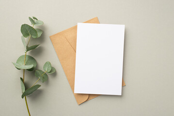 Business concept. Top view photo of paper sheet craft paper envelope and eucalyptus on pastel grey...