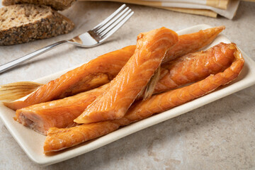 Fresh smoked salmon bellies on a plate close up 
