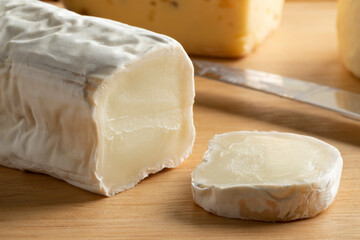  Buche de Chevre, goat cheese, and a slice close up on a cutting board