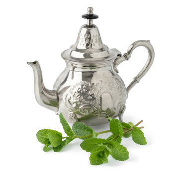 Moroccan teapot and twig of fresh mint isolated on white background